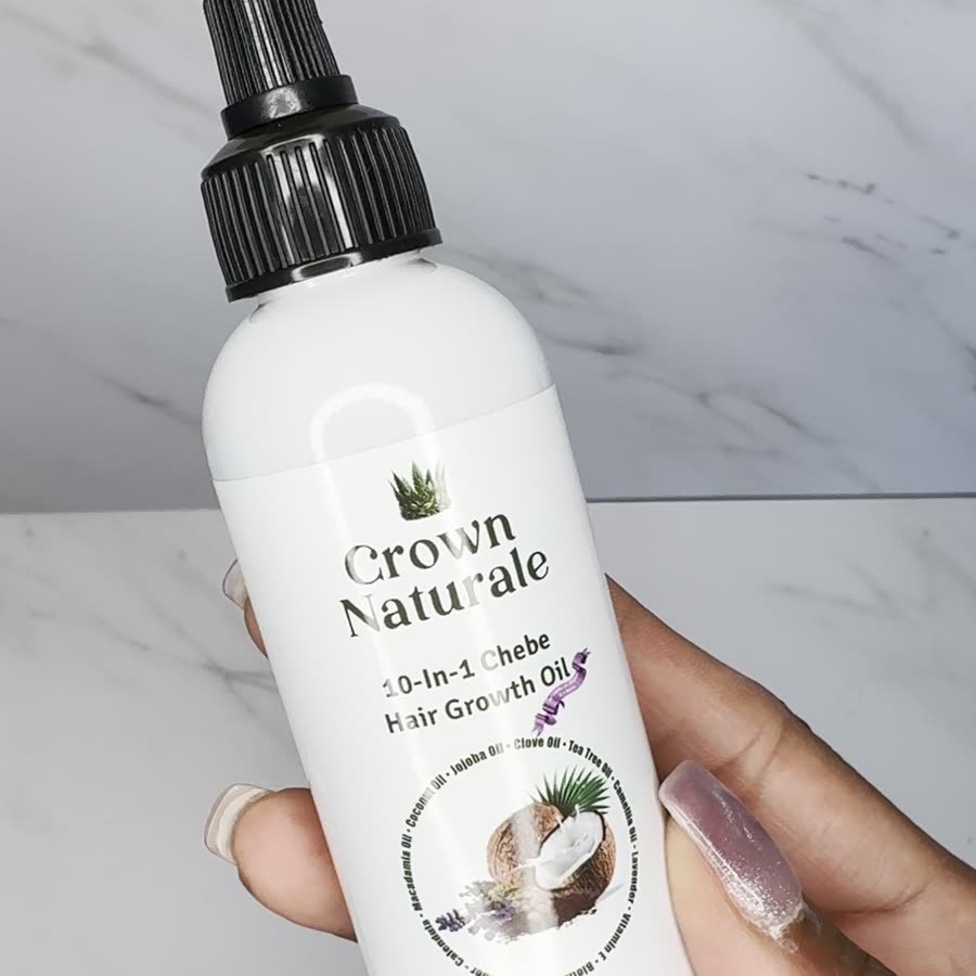 Hand holding the 10-in-1 Chebe Hair Growth Oil